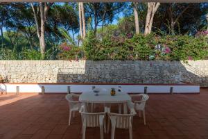 a white table and chairs on a patio at L'isola di Gianni by Ortigia Apartments in Plemmirio