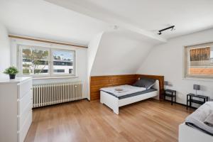 um quarto com uma cama e duas janelas em home2stay worker Apartment Nürtingen bis zu 200 Betten em Nürtingen