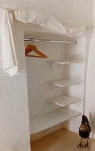 un uccello in piedi in un armadio con scaffali bianchi di Mambo Salentino Guest House Room 16 a Matino