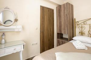 a bedroom with a bed with a mirror and a wooden door at Sun And Stone in Athani