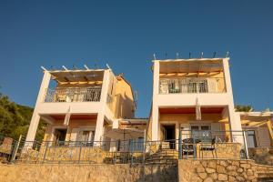 two white buildings with balconies on top of a wall at Sun And Stone in Athani