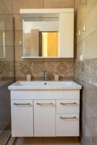 ein Badezimmer mit einem weißen Waschbecken und einem Spiegel in der Unterkunft Sun And Stone in Athani