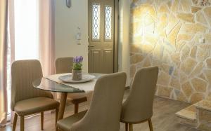 a dining room with a table and chairs and a stone wall at Sun And Stone in Athani