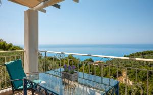 a balcony with a table and a view of the ocean at Sun And Stone in Athani