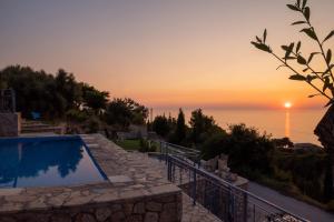 a sunset over the ocean with a swimming pool at Sun And Stone in Athani