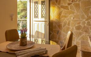 a dining room table with a stone wall at Sun And Stone in Athani