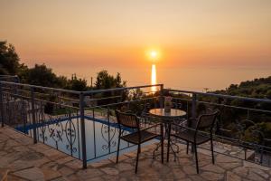 a balcony with a table and chairs and the sunset at Sun And Stone in Athani