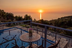 a balcony with a table and a view of the ocean at Sun And Stone in Athani