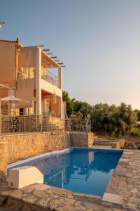 a villa with a swimming pool in front of a house at Sun And Stone in Athani