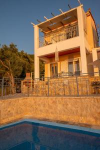 a house with a pool in front of it at Sun And Stone in Athani
