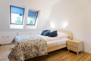 a white bedroom with a bed and two windows at Apartamenty na Równi w Centrum Apartzakop in Zakopane