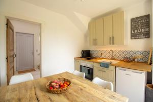 - une cuisine avec une table et un bol de fruits dans l'établissement Au cœur des champs - Gîte, à Nivelles