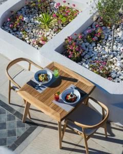 einen Tisch mit zwei Teller Essen auf einer Terrasse in der Unterkunft Danae Suites Santorini in Oia