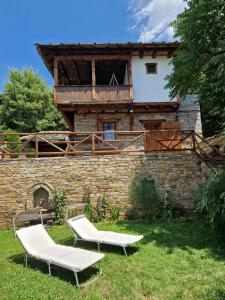 2 sillones blancos frente a un edificio en Leshten Valentin's House, en Leshten