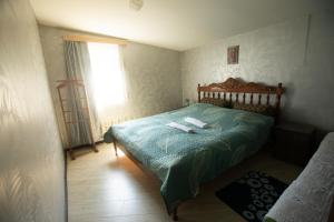 ein Schlafzimmer mit einem Bett mit einer grünen Bettdecke und einem Fenster in der Unterkunft Strawberry in Bordschomi