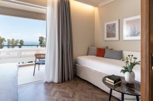 ein Schlafzimmer mit einem Bett und einem Balkon in der Unterkunft Kerkyra Blue Hotel & Spa by Louis Hotels in Korfu-Stadt