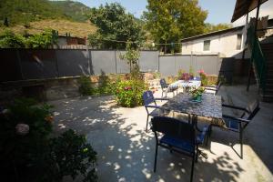 a patio with a table and chairs in a backyard at Strawberry in Borjomi