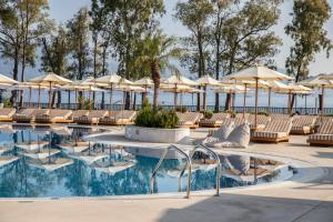 a pool with chairs and umbrellas at a hotel at Kerkyra Blue Hotel & Spa by Louis Hotels in Corfu Town