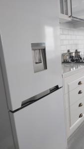 einen weißen Kühlschrank in einer Küche mit Spüle in der Unterkunft Modern apartment in Batumi