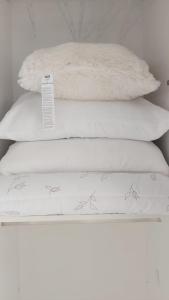 zwei Stapel weißer Kissen auf einem Bett in der Unterkunft Modern apartment in Batumi