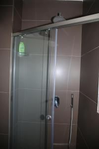 a shower with a glass door in a bathroom at Pashkaj Hotel in Pogradec