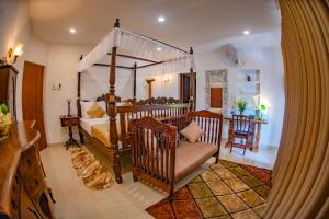 1 dormitorio con 1 cama grande con dosel y 1 silla en The Castle by Don Louis en Kandy