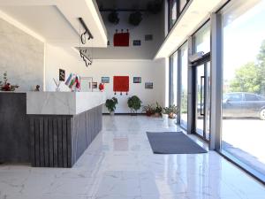 an office lobby with a reception counter and large windows at Jansyn Hotel Restaurant in Karakol