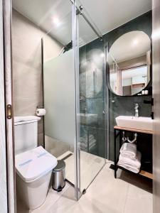 a bathroom with a shower and a toilet and a sink at La Mer Luxury Apartments in Ierissos