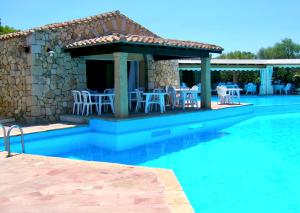 Un complejo turístico con piscina, mesa y sillas. en ISA-Residence with swimming-pool in Porto Rotondo at only 500 m from the beach, en Porto Rotondo