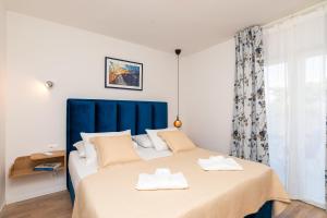 une chambre avec un grand lit et une tête de lit bleue dans l'établissement Deluxe apartment BRAČOLET private pool, à Supetar