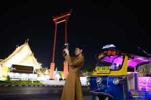 a woman taking a picture of a vehicle at night at Sheraton Grande Sukhumvit, a Luxury Collection Hotel, Bangkok in Bangkok +160 photos