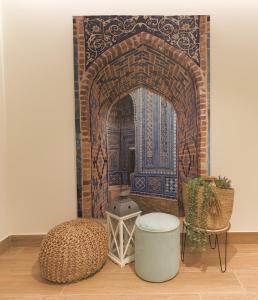 a room with a moroccan doorway with a table and a stool at Dorinda Rooms in Alicante