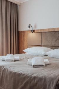 two beds with white towels on top of them at Pomorze Health & Family Resort in Ustka