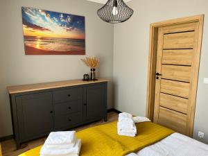 1 dormitorio con 1 cama y vestidor con toallas en Apartamenty Ustronie Morskie 31B3, en Ustronie Morskie