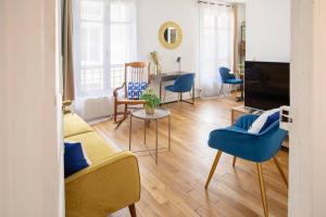 a living room with a couch and chairs and a table at Chic appartement proche métro in Paris