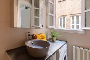 a bathroom with a large bowl sink on a counter at Chic appartement proche métro in Paris