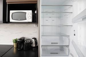 a kitchen with a refrigerator with a microwave at Chic appartement proche métro in Paris