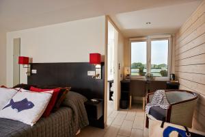 ein Schlafzimmer mit einem Bett und einem Schreibtisch in einem Zimmer in der Unterkunft Logis Hôtel de la Pointe du Cap Coz in Fouesnant
