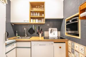 a kitchen with white cabinets and a sink at Le Flocon - Chamrousse 1750 - Sur les pistes in Chamrousse