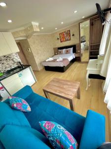 a living room with a blue couch and a bed at Elegance Aparts Cihangir in Istanbul