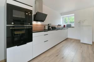 PicauvilleにあるAu 2 ailes - Charmante maison pour 7のキッチン(白いキャビネット、黒の電化製品付) +5枚の写真