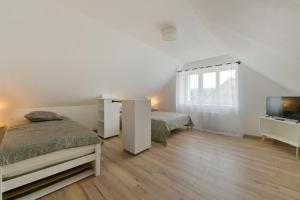 um quarto com 2 camas e uma televisão de ecrã plano em Au 2 ailes - Charmante maison pour 7 em Picauville