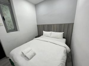 een kleine slaapkamer met 2 bedden met witte lakens bij MyHome TPB Taragon in Kuala Lumpur