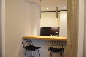 een keuken met twee zwarte stoelen en een aanrecht bij Appartamento di design con terrazza privata in Rome