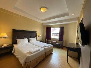 una camera d'albergo con un grande letto e una TV di Roma Hotel a Khon Kaen