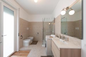 ein Badezimmer mit einem Waschbecken, einem WC und einem Spiegel in der Unterkunft Paola Maison NEW APARTMENT! in Pescara