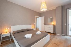una camera da letto con un grande letto con due asciugamani di Paola Maison NEW APARTMENT! a Pescara
