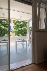 eine Glasschiebetür, die auf eine Terrasse mit einem Tisch führt in der Unterkunft Paola Maison NEW APARTMENT! in Pescara