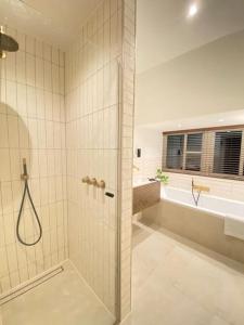 een badkamer met een douche, een wastafel en een bad bij Parkzicht in Leeuwarden