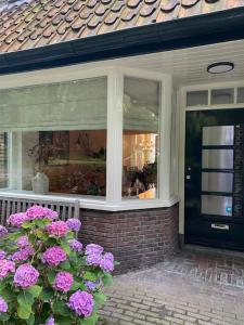 una puerta de entrada de una casa con flores rosas en Parkzicht, en Leeuwarden